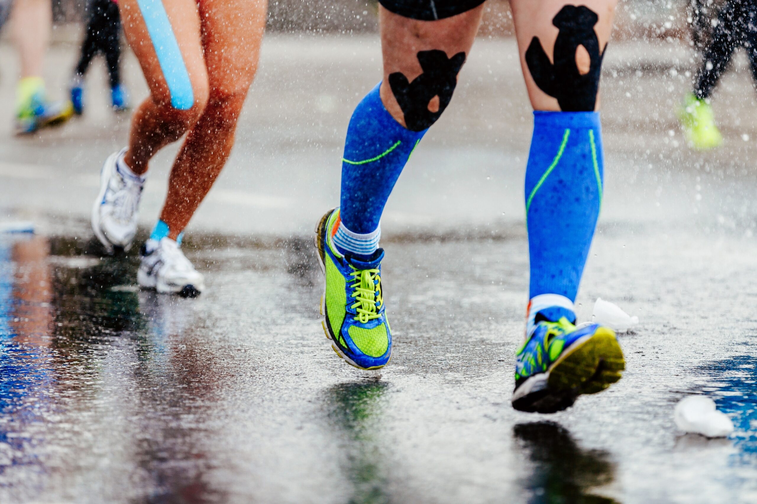 Athletic runner close up on shoes in the rain while wearing compression socks.