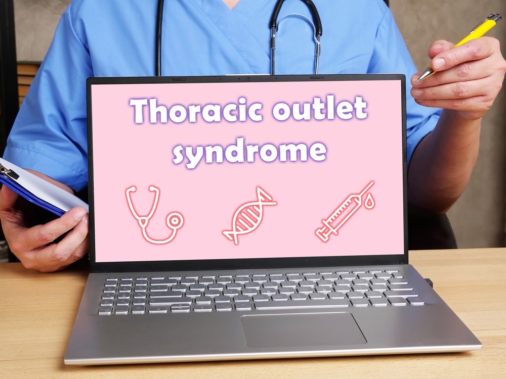 A doc sits behind a laptop that reads "Thoracic Outlet Syndrome."